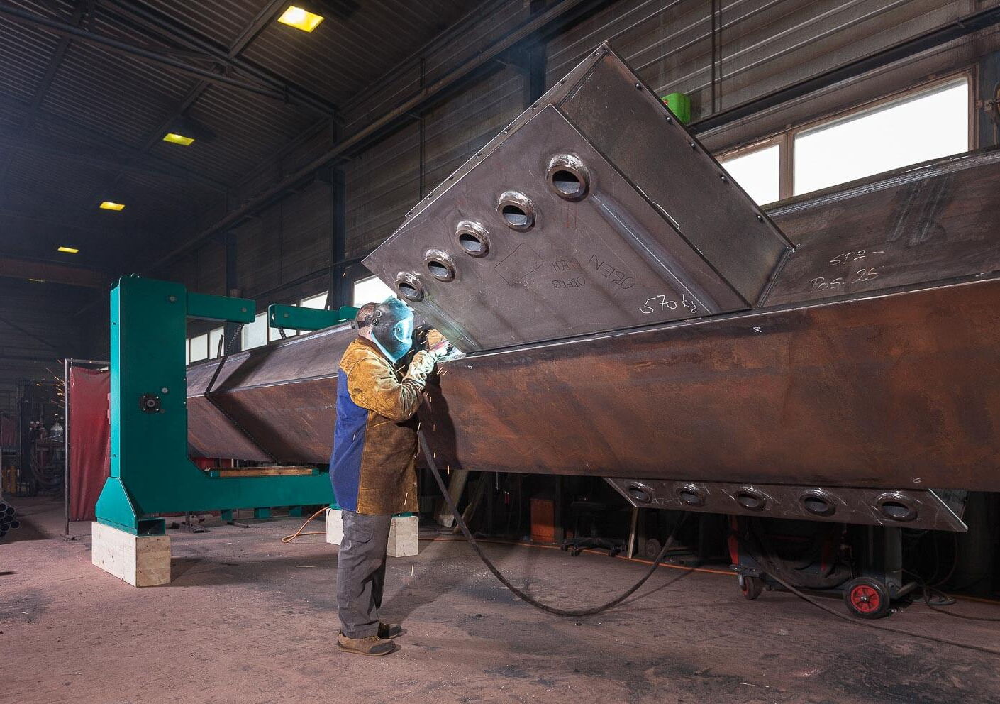 Industriefotografie Stahlträgerproduktion mit Schweisser und Schweissanlage