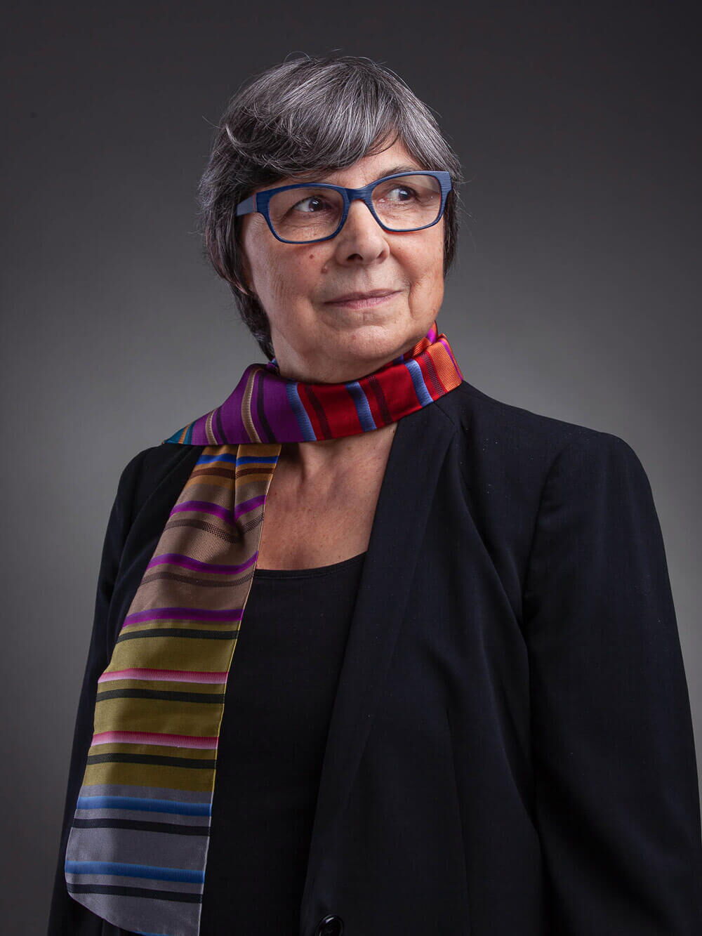 Portraitfotograf Luzern - Portraitfotografie einer Frau in schwarzem Anzug mit farbigem Seidenschal