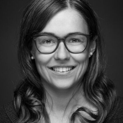 Portraitotografie von junger Frau mit Brille und Naturlocken