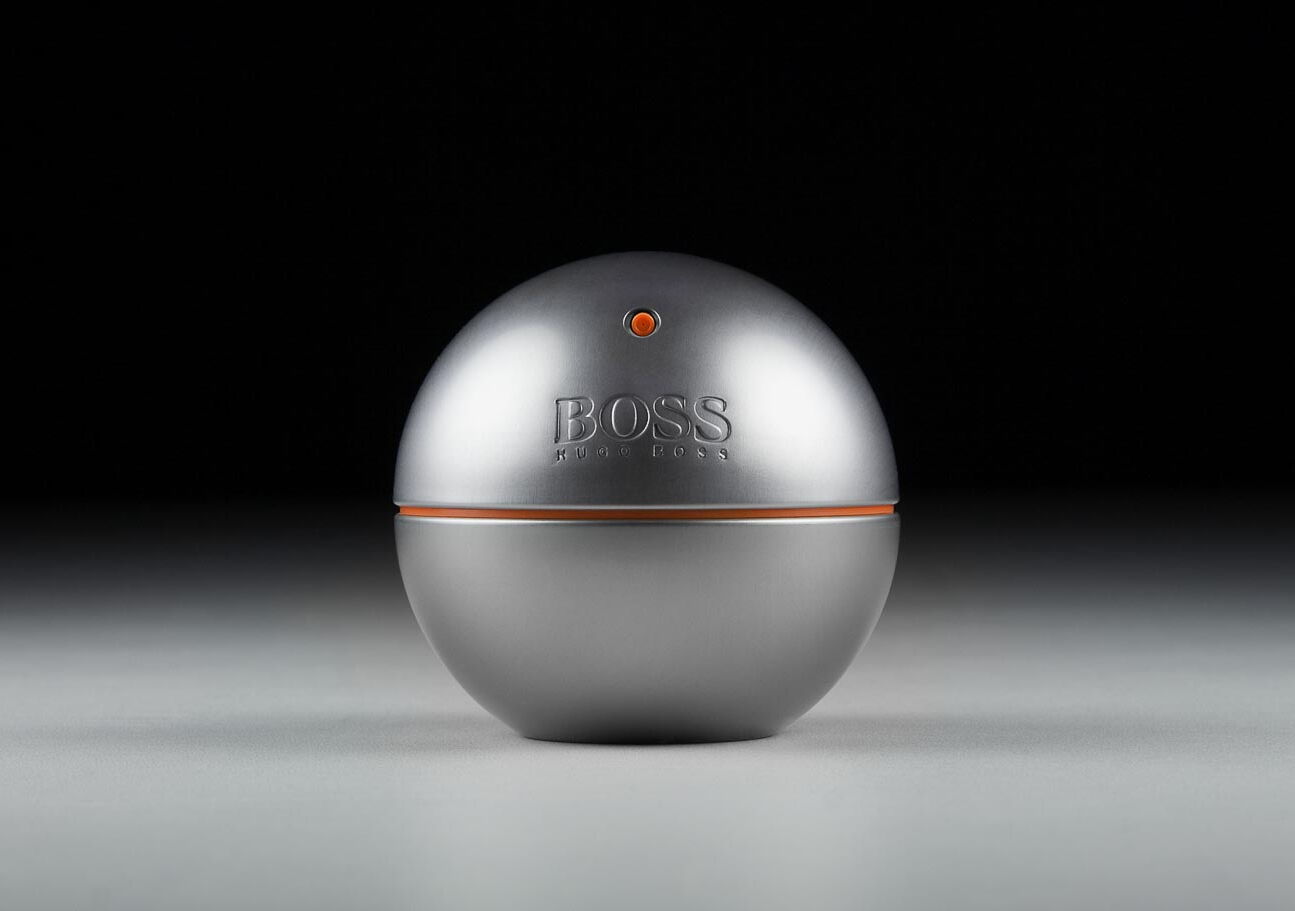 Werbefotografie: Rundes silbernes Boss Parfumflacon auf grauem Untergrund